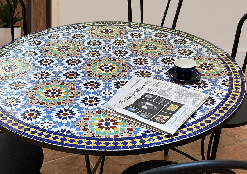 Stylish round mosaic coffee table with four chairs featuring intricate Moroccan tiles for a chic decor touch